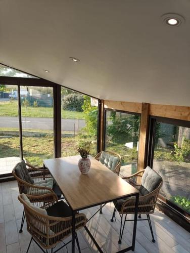 a dining room with a table and chairs and windows at Maison à Vieux Boucau les Bains in Vieux-Boucau-les-Bains