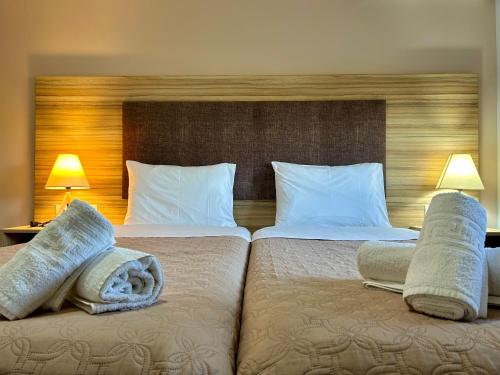 a hotel room with two beds with towels on them at Ktima Bilionis in Kakóvatos