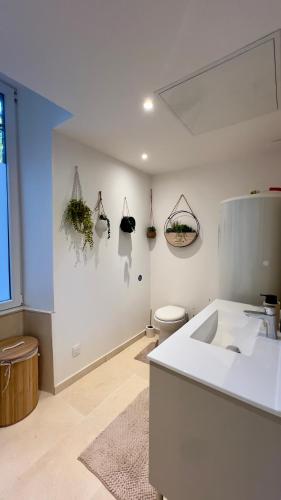 une salle de bain blanche avec un lavabo et des toilettes dans l'établissement La grange du château Favor, à Bourg-de-Péage