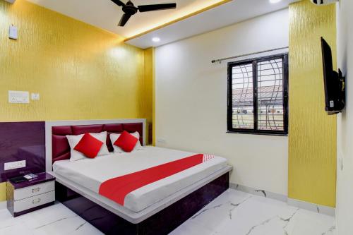 a bedroom with a bed with red and yellow walls at Hotel O One Plus Inn in Itwāri