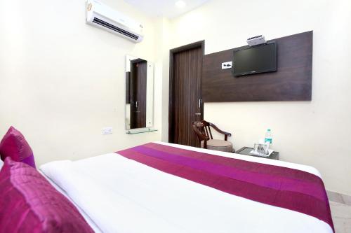 a bedroom with a bed and a tv on the wall at Hotel The Grandpark in Amritsar