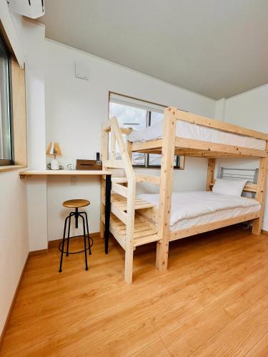 七尾市にあるhotel kusanagiの二段ベッド2台と机のある寝室