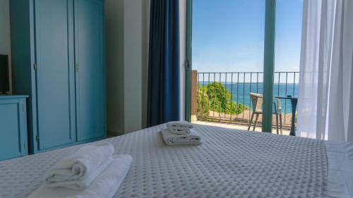 a bedroom with a bed with a view of the ocean at AHG Riva Del Sole Hotel - Adults Only in Moniga