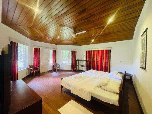 a bedroom with a large bed and a wooden ceiling at Herondale Estate Bunglow in Nawalapitiya