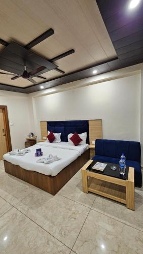 a bedroom with a bed and a couch and a table at Hotel Green View McLeod Ganj in Dharmsala