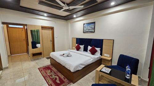 a bedroom with a bed and a blue chair at Hotel Green View McLeod Ganj in Dharmsala