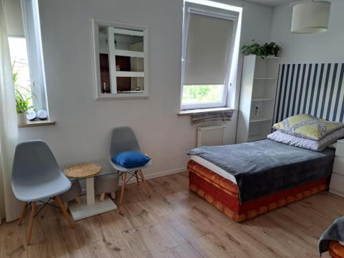 una camera da letto con un letto, due sedie e un tavolo di Apartament Julia 1-2 os Warszawska 28 Centrum a Kielce