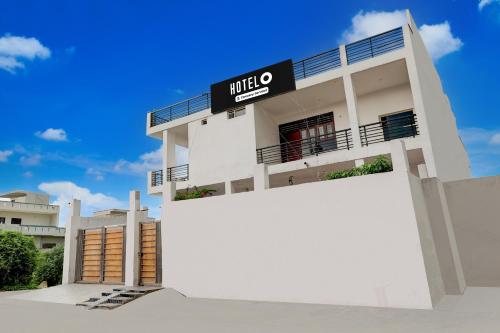 a white building with a sign on it at Hotel O Eden Garden Faridabad Formerly Ziva Stays in Ballabgarh