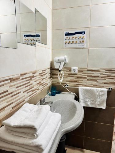 a bathroom with a sink with towels on it at Pensiune Restaurant Indus in Ocna Sibiului