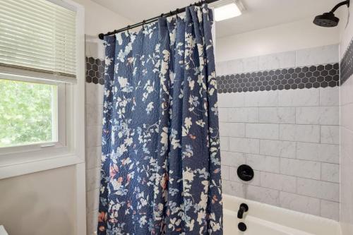 a bathroom with a shower curtain with flowers on it at Waterfront 5 Br Pool Hot Tub Pavilion Fire Pit in Elkton