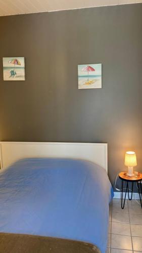 une chambre avec un lit et une table avec une lampe dans l'établissement LES TRÉMIÈRES N°1 - A 5MN DES PLAGES A VELO, à La Michelière