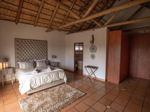 a bedroom with a bed and a table in it at Weavers Nest Guesthouse in Modimolle