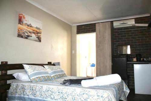 a black cat laying on a bed in a bedroom at Delion Lodge in Koster