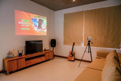 a living room with a couch and a flat screen tv at Paradise Itzu in Kandy