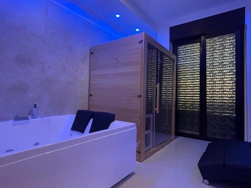 a bathroom with a bath tub with two black chairs at B&B CORSO ROMA Room Suite & Spa in Apricena
