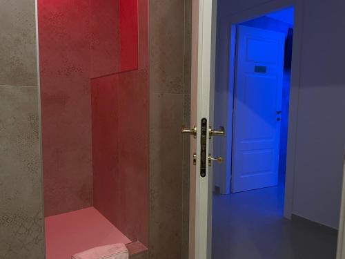 an open door to a bathroom with a red and blue door at B&B CORSO ROMA Room Suite & Spa in Apricena