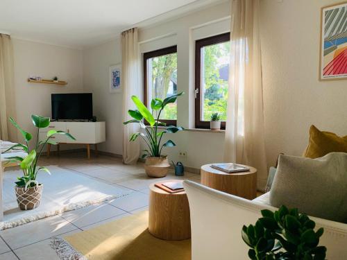 a living room with potted plants and a television at angekommen - Ferienwohnung nahe Basel in Lörrach