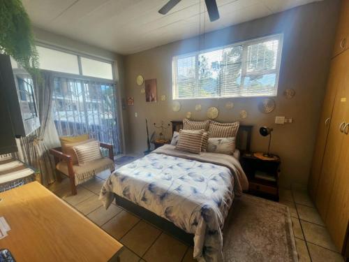 a bedroom with a bed and two windows at Primrose Accommodation in George