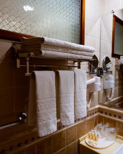 baño con toallas colgadas en un estante en Omar Khayyam Hotel, en Bukhara