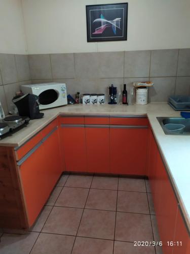a kitchen with red cabinets and a microwave at Chen Ba'Galil in Kahal