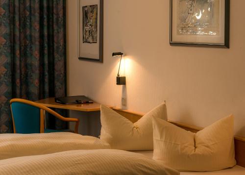 a hotel room with a bed and a desk with a lamp at Median Hotel Garni in Wernigerode