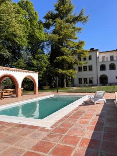 a swimming pool with a chair next to a building at Can Passarells in San Vicente de Torelló