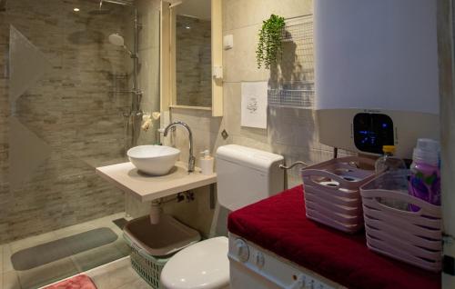 a bathroom with a sink and a toilet with a red bench at Melone Apartman 3 Senj by Villas Guide in Sveti Juraj