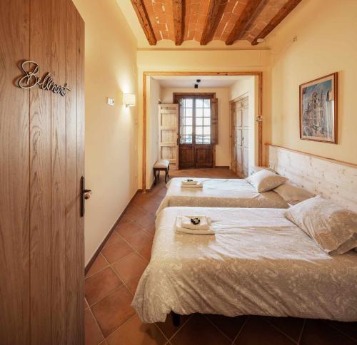a bedroom with three beds in a room at Can Passarells in San Vicente de Torelló