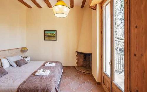 a bedroom with a large bed and a fireplace at Can Passarells in San Vicente de Torelló