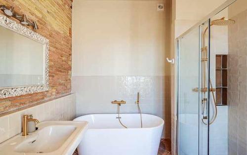 a bathroom with a tub and a sink and a shower at Can Passarells in San Vicente de Torelló