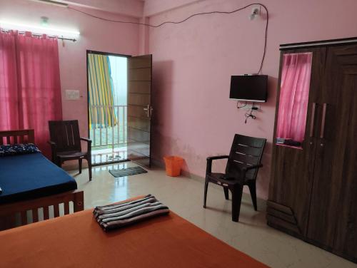 a living room with a bed and a table and chairs at Roamwander Apartments in Vagamon