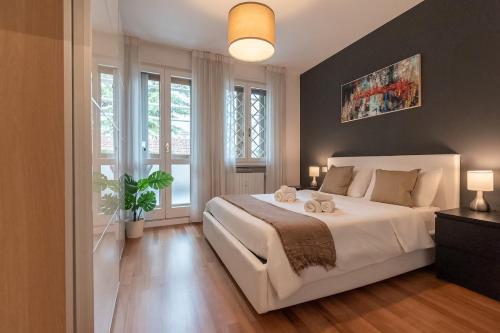 パドヴァにあるAttico di lusso in pieno centro a Padovaの大きな白いベッドと窓のある寝室
