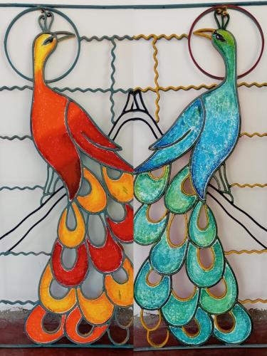 two stained glass peacocks hanging on a wall at Belihuloya Escape and Cafe in Belihul Oya