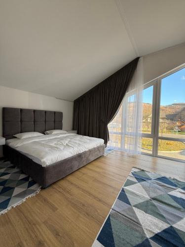 a bedroom with a large bed and a large window at Yaremche Apartments in Yaremche