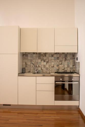 a kitchen with white cabinets and a sink at BADIA NUOVA Apart Hotel in Trapani