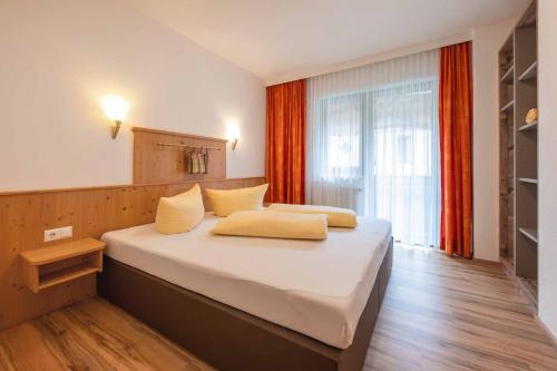 a bedroom with a large white bed and a window at Apart&Chalet Chiara in Neustift im Stubaital