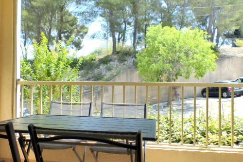 - un balcon avec une table et des chaises sur une terrasse couverte dans l'établissement Studio with pool in the heart of Sanary-sur-Mer, à Sanary-sur-Mer