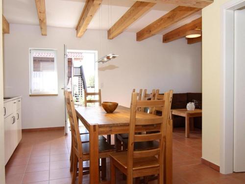 une cuisine et une salle à manger avec une table et des chaises en bois dans l'établissement Farmstay Neuendorfkrug, Lütow, à Lütow