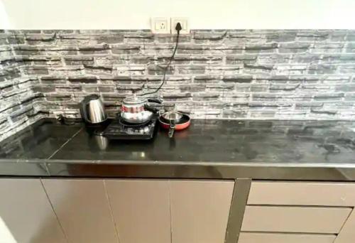 a kitchen counter top with a stove and pots and pans at The Driftwood Dan Studio Flat Colva, anirah in Colva