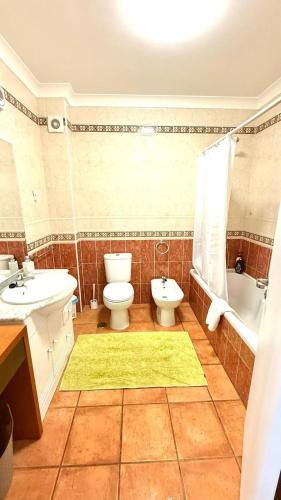 a bathroom with a toilet and a sink and a bath tub at Large three-bedroom apartment in Lagos