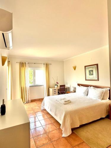 a bedroom with a large white bed and a window at Large three-bedroom apartment in Lagos