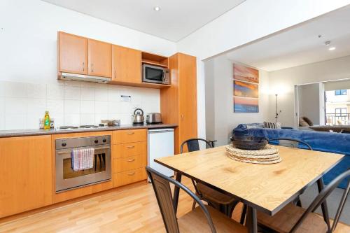 a kitchen and dining room with a table and chairs at 404 Big Beautiful One Bed & Balcony in Perth
