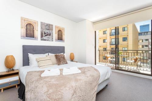 a bedroom with a bed and a large window at 404 Big Beautiful One Bed & Balcony in Perth