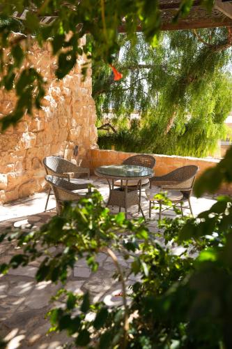 a patio with a table and chairs and a stone wall at Hayat Zaman Hotel And Resort Petra in Wadi Musa