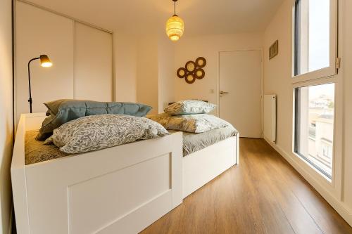 Un dormitorio con dos camas y una ventana. en Charmant appartement cosy et paisible proche Paris - métro à 2min, en Romainville