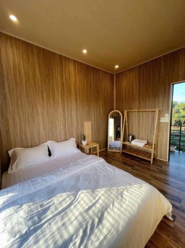 a bedroom with a large bed and a mirror at Han San Homestay Măng Đen in Kon Plong
