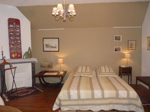 a bedroom with a bed and a fireplace at Le point d'orgue in Pineuilh