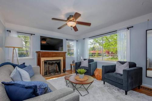 a living room with a ceiling fan and a fireplace at Style Meets Comfort in Beautiful Design in Vancouver
