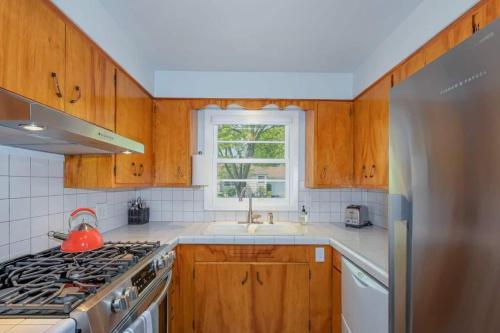 a kitchen with a stove and a sink and a window at Style Meets Comfort in Beautiful Design in Vancouver