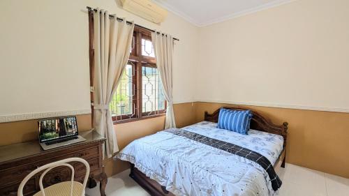 a bedroom with a bed and a window at Surabaya Homey Dharmahusada Syariah in Surabaya